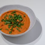 Creamy carrot soup garnished with fresh herbs