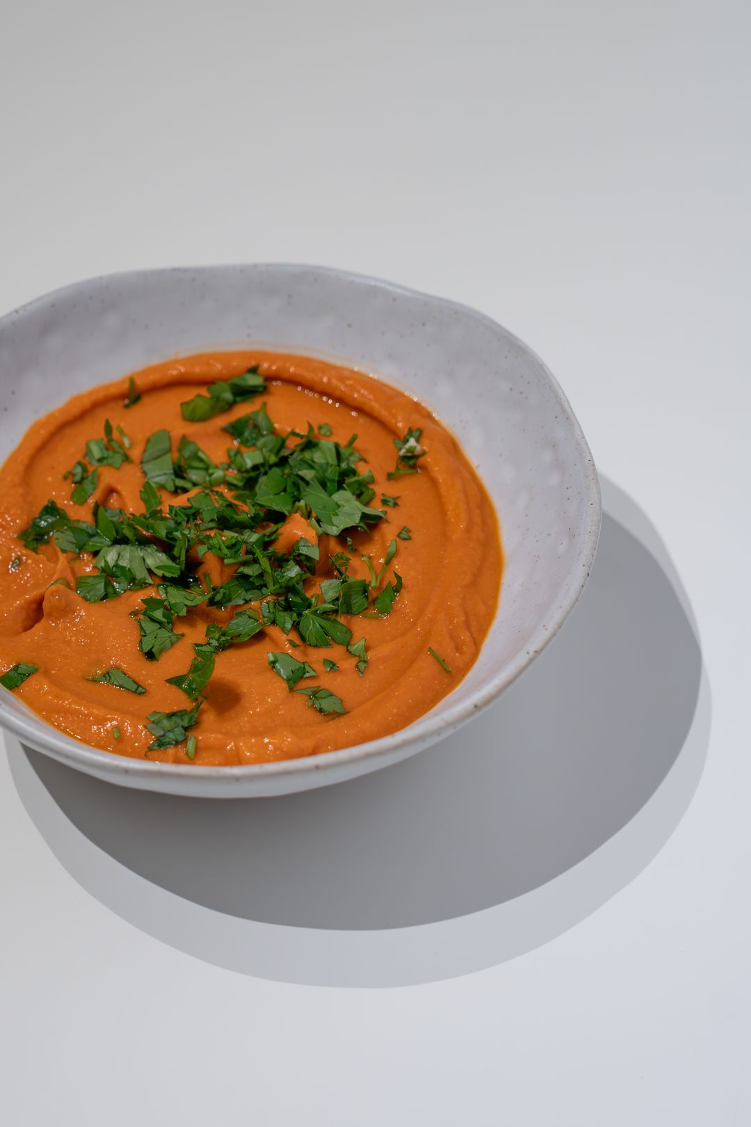 Creamy carrot soup garnished with fresh herbs